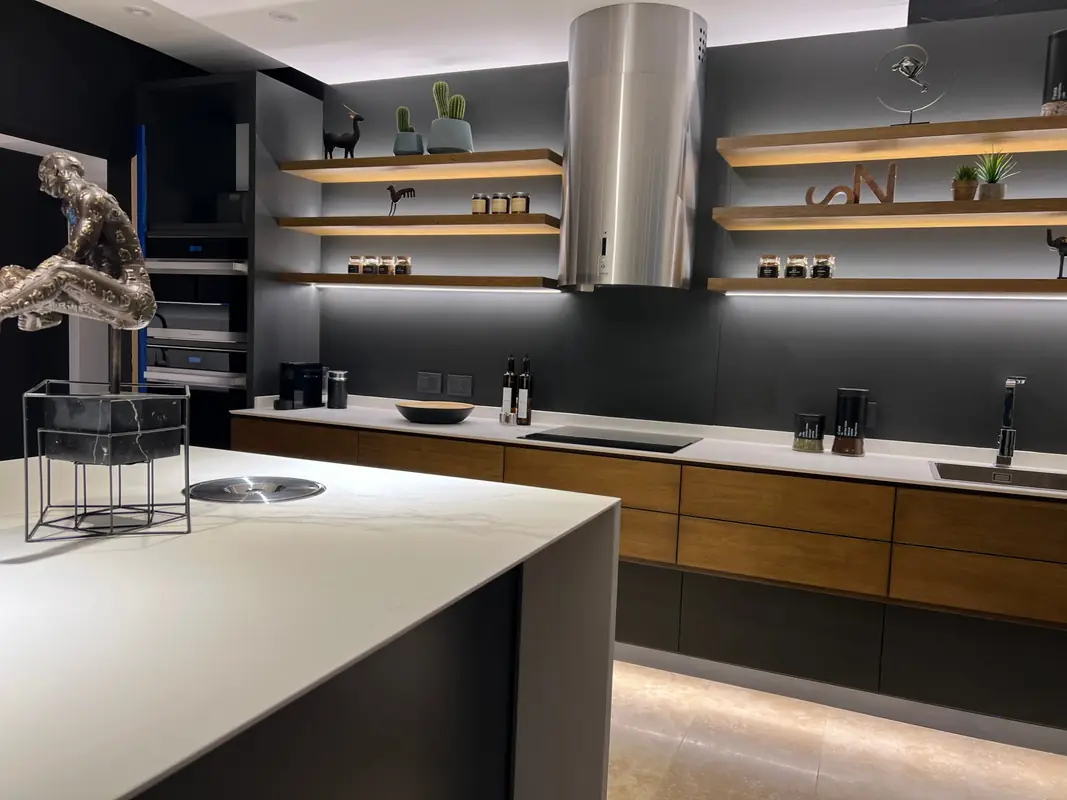 Cocina con estantes de madera iluminados con LED y campana de acero