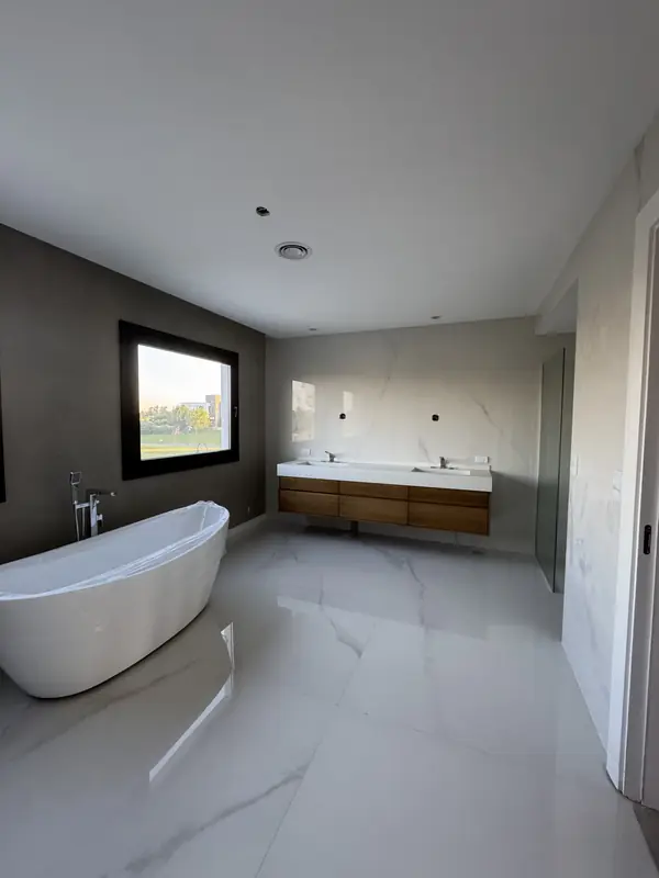 Baño en suite con bañera exenta y vanitory de madera