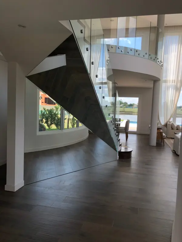 Escalera revestida en madera con baranda de vidrio